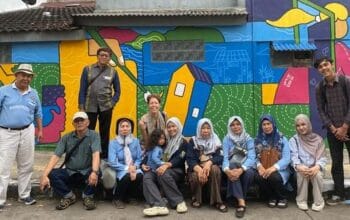 Foto bersama usai kegiatan dengan latar belakang mural tematis dan estetis karya pemuda setempat dan luar daerah. (Ist)