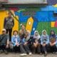 Foto bersama usai kegiatan dengan latar belakang mural tematis dan estetis karya pemuda setempat dan luar daerah. (Ist)
